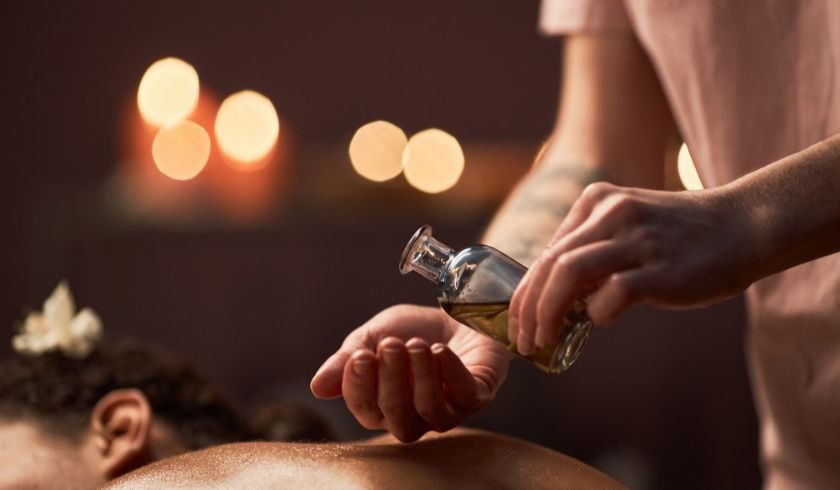 therapist pouring aromatherapy oil onto their hands before massage 