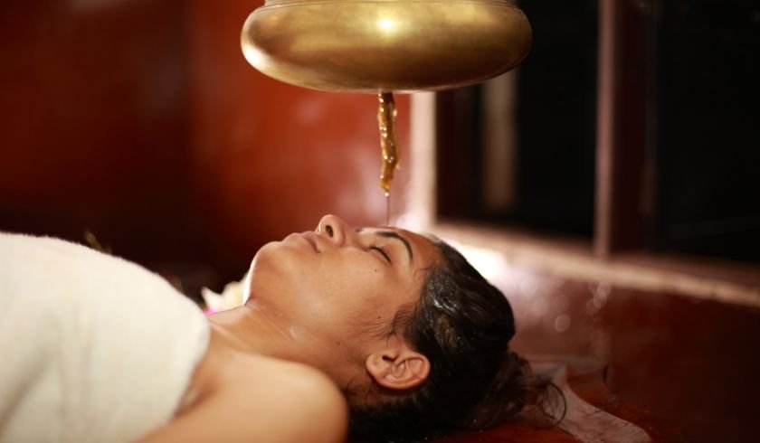 a client receiving a shirodhara treatment in chiang mai