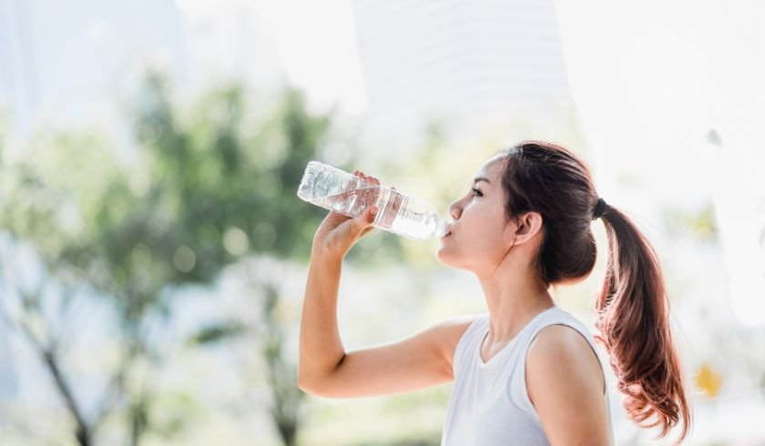 woman drinking water to stay hydrated after her massage alleviate jet lag symptoms